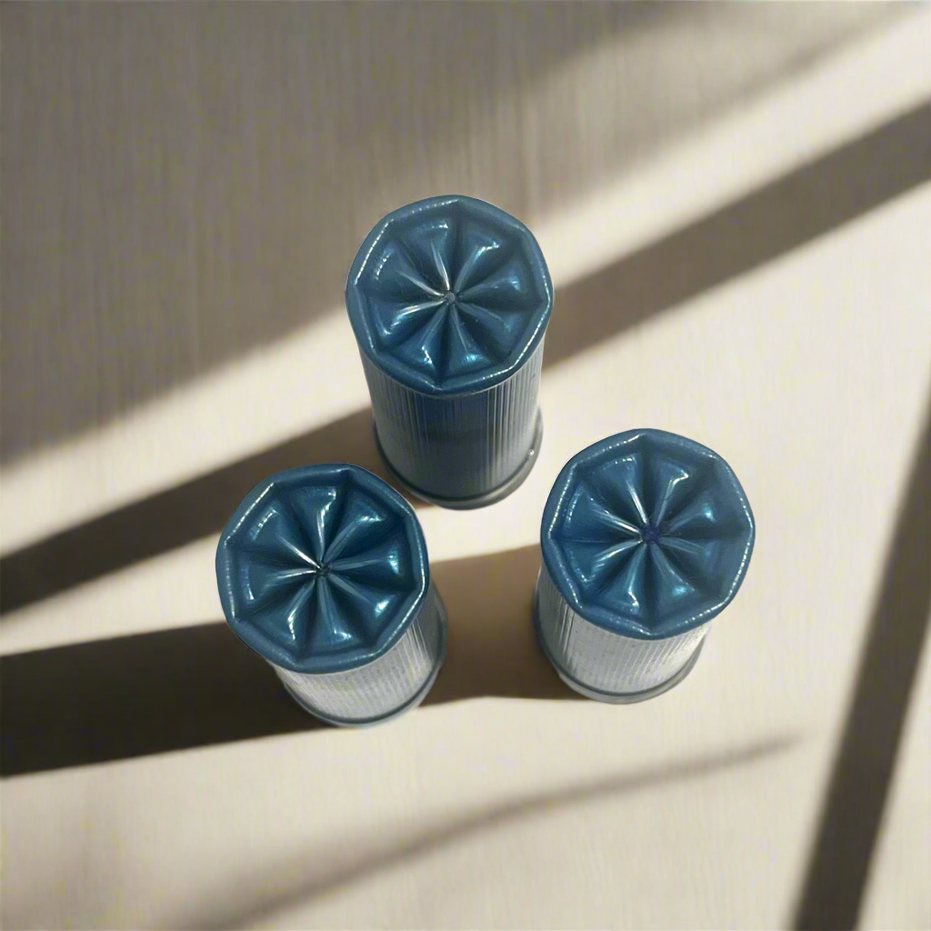 Three blue dummy shotgun shells viewed from above showing fluted crimped tops in sunlight