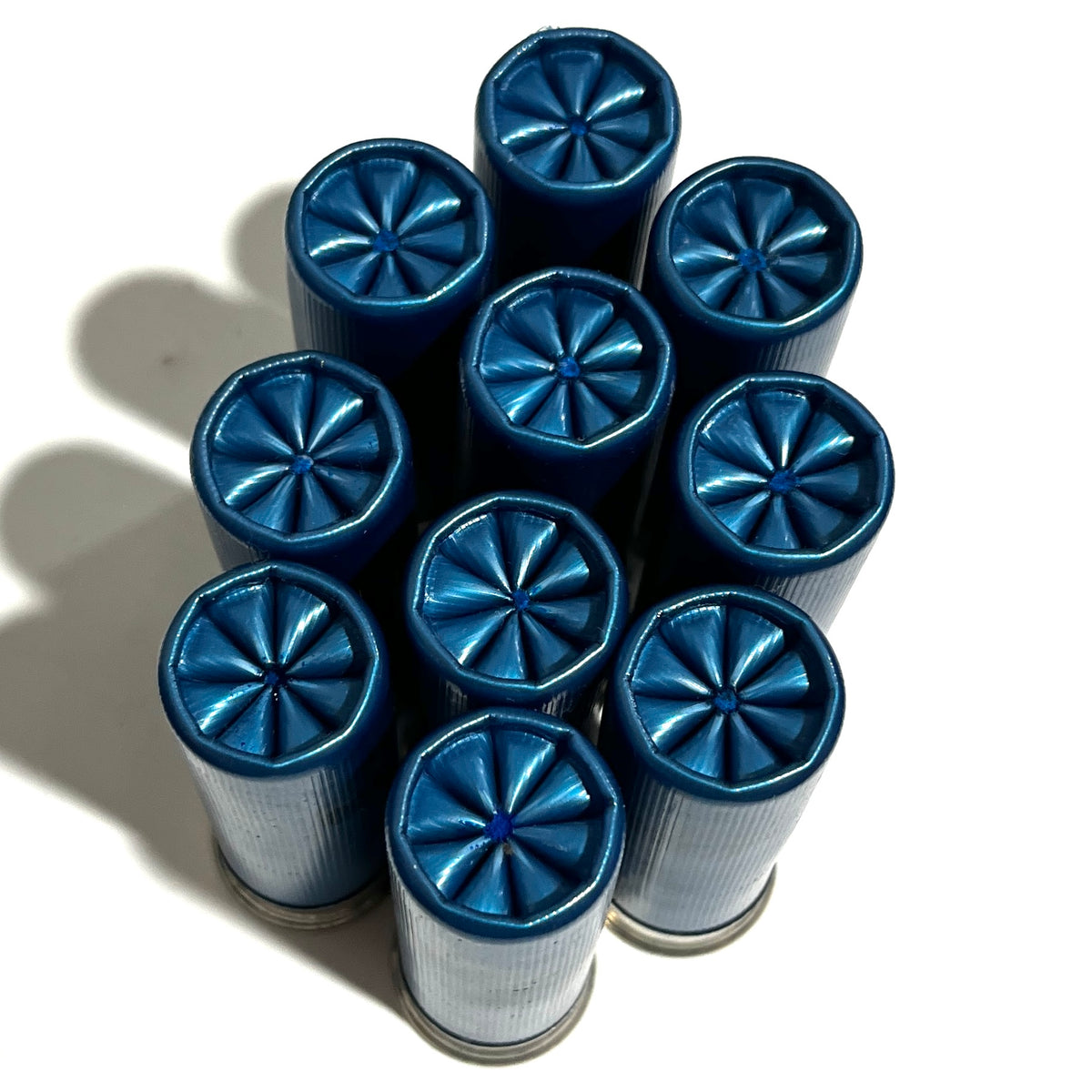 Nine blue dummy shotgun shells viewed from above showing fluted crimped tops