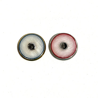 Two authentic thin-cut (approx 3.3mm) once-fired 12-gauge shotgun shell slices with red and blue spent primer centers, each featuring an engraved cross silhouette, displayed on a white background.
