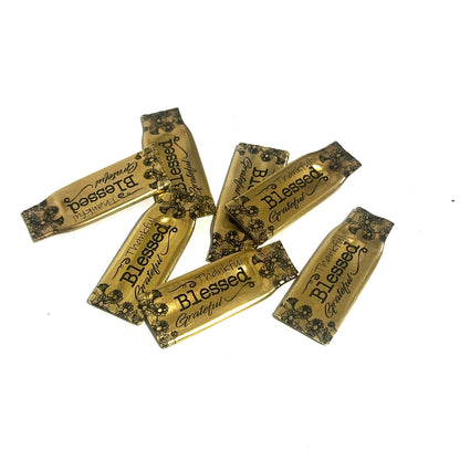Group of flattened gold-brass .308 casings showing variations in shape and floral engraving placement