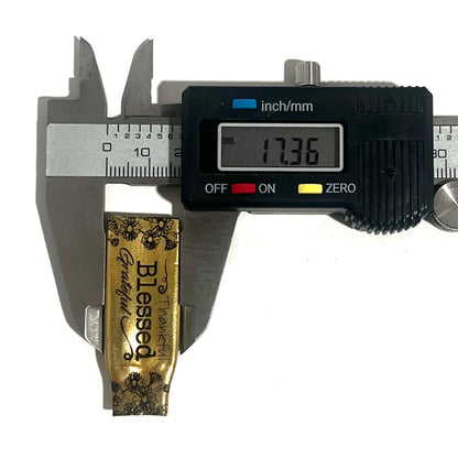 Digital caliper measuring an engraved flattened .308 brass casing at 17.36 millimeters wide
