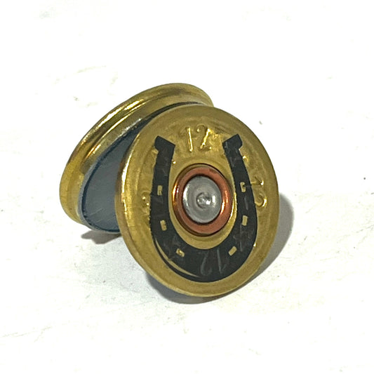 Gold 12 gauge shotgun shell slice engraved with a horseshoe design, standing on edge