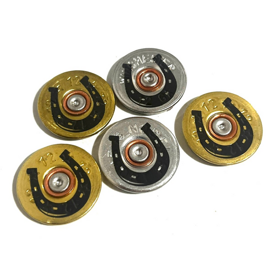 5 shotgun shell slices engraved with a horseshoe design in gold and silver, marked 12 gauge, with copper primers
