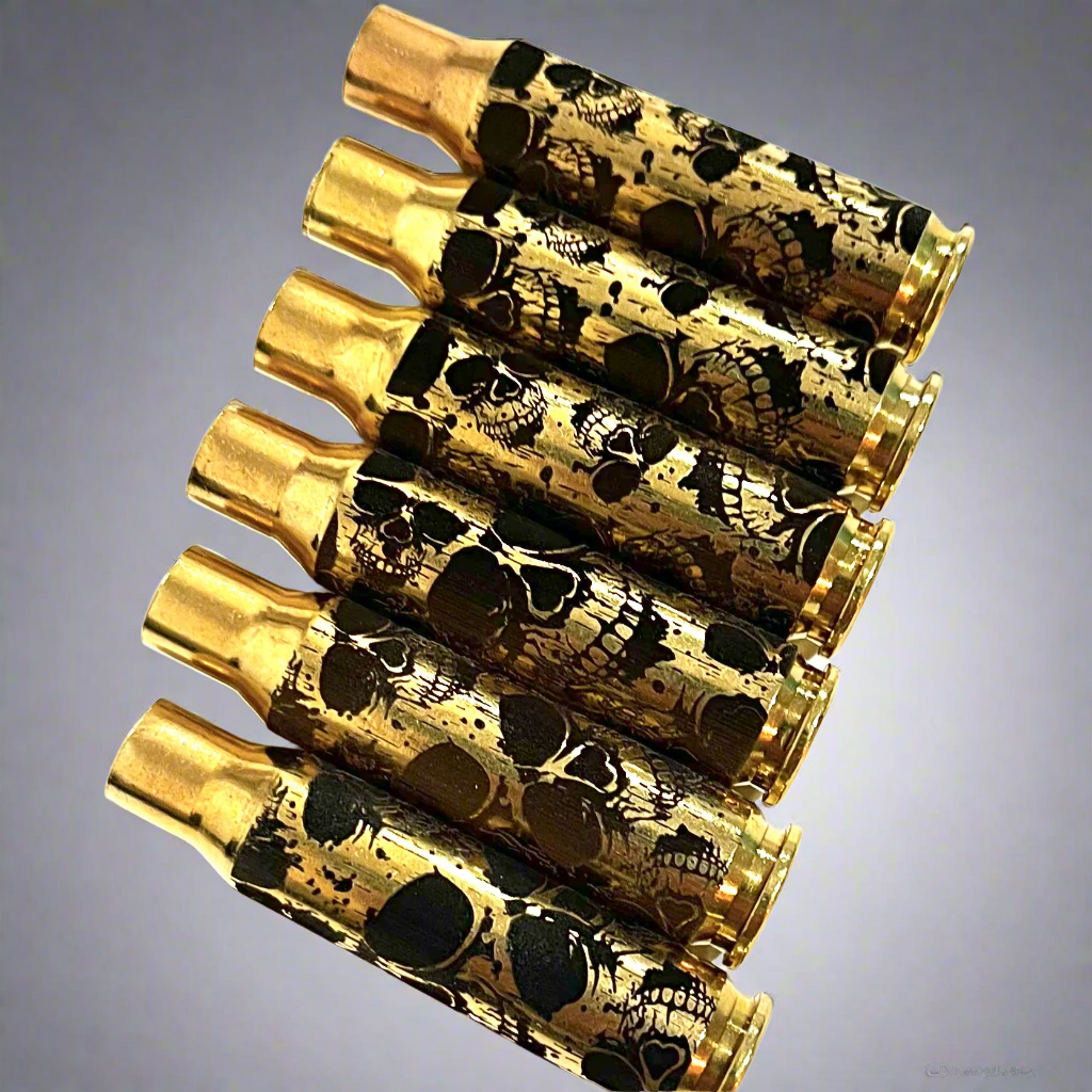 Five 308 WIN brass casings lined up side-by-side with laser-engraved skull graphics.