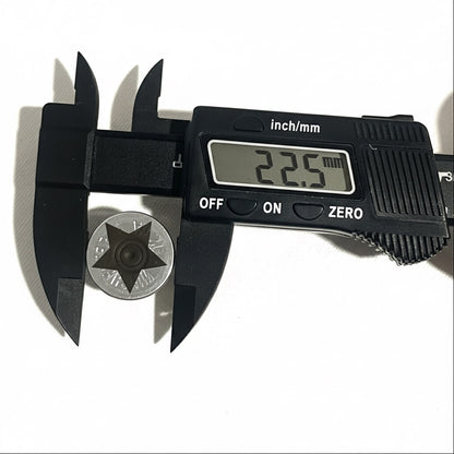 Digital caliper measuring the diameter of a silver engraved star shotgun shell slice at 22.5 millimeters