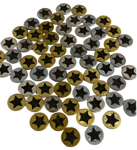 Large pile of mixed silver and gold 12 gauge shotgun shell slices with black engraved star designs on a white background