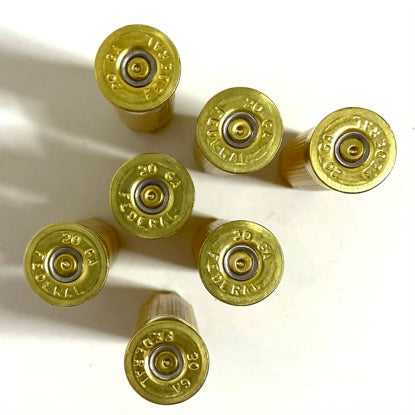 Federal 20 gauge empty shotgun shells, yellow hulls showing brass headstamps for making custom pocket watches or cufflinks.
