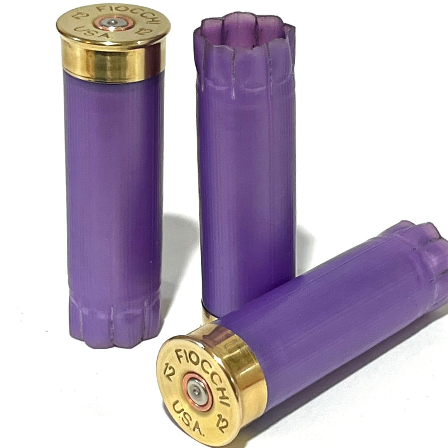 Three light purple shotshells with brass heads stamped Fiocchi 12 USA, one showing an open crimped top