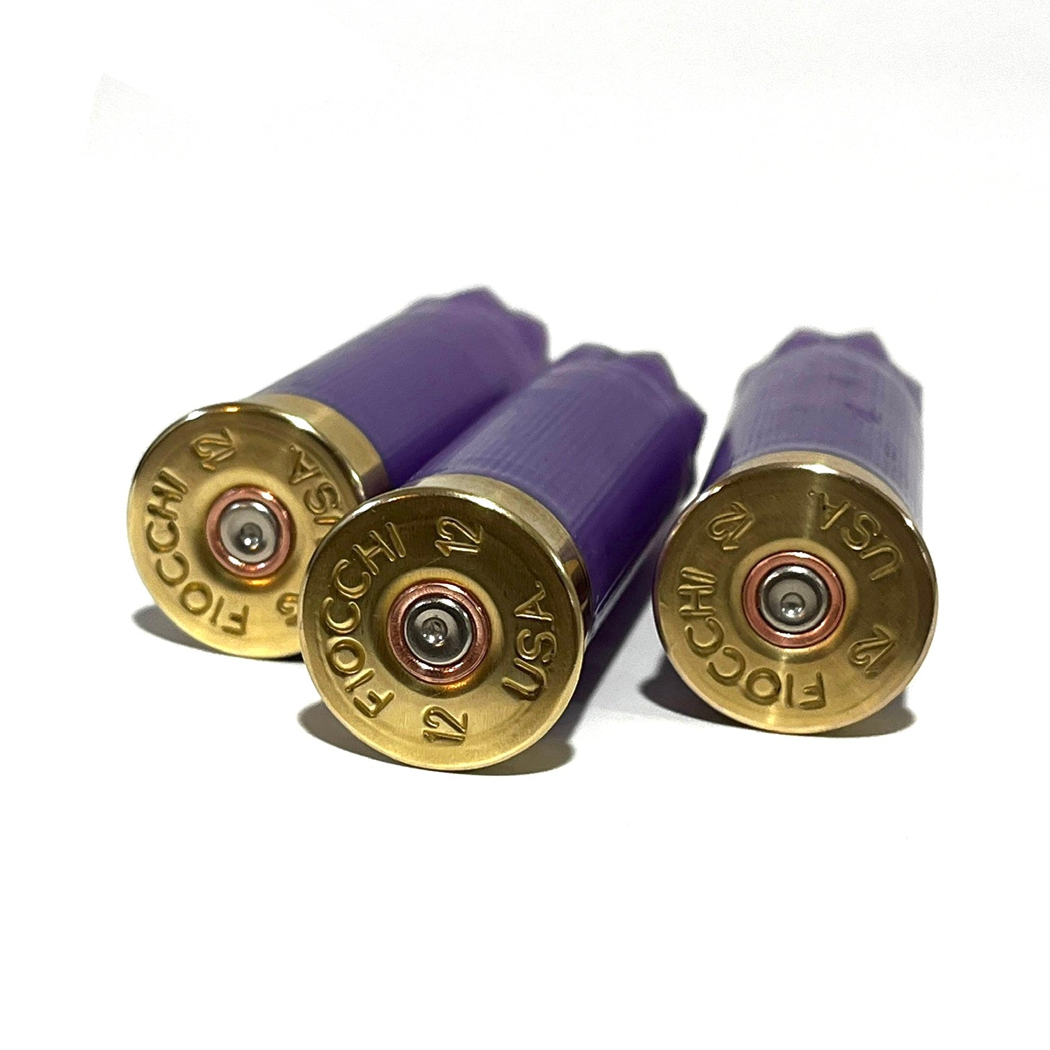 Three light purple cartridges with brass bases stamped Fiocchi 12 USA, viewed close-up