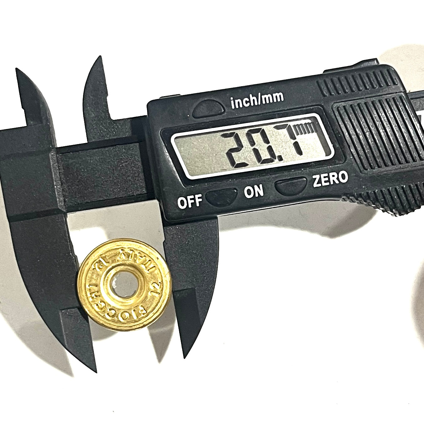 Gold Fiocchi 12 gauge deprimed casing bottom measured with a caliper reading 20.1mm in diameter.