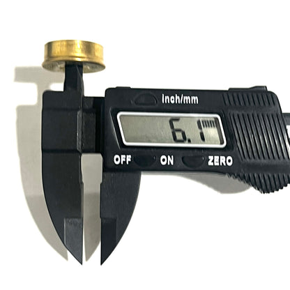 Gold Fiocchi 12 gauge headstamp primer hole measured with a digital caliper reading 6.1 millimeters thick.