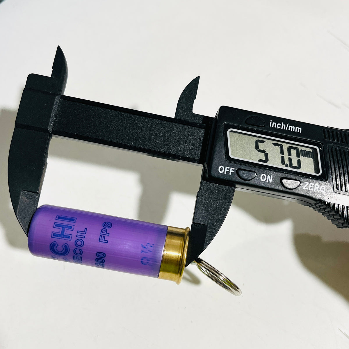 Digital caliper measuring the lavender Fiocchi 12 gauge hull at 57.0 mm long