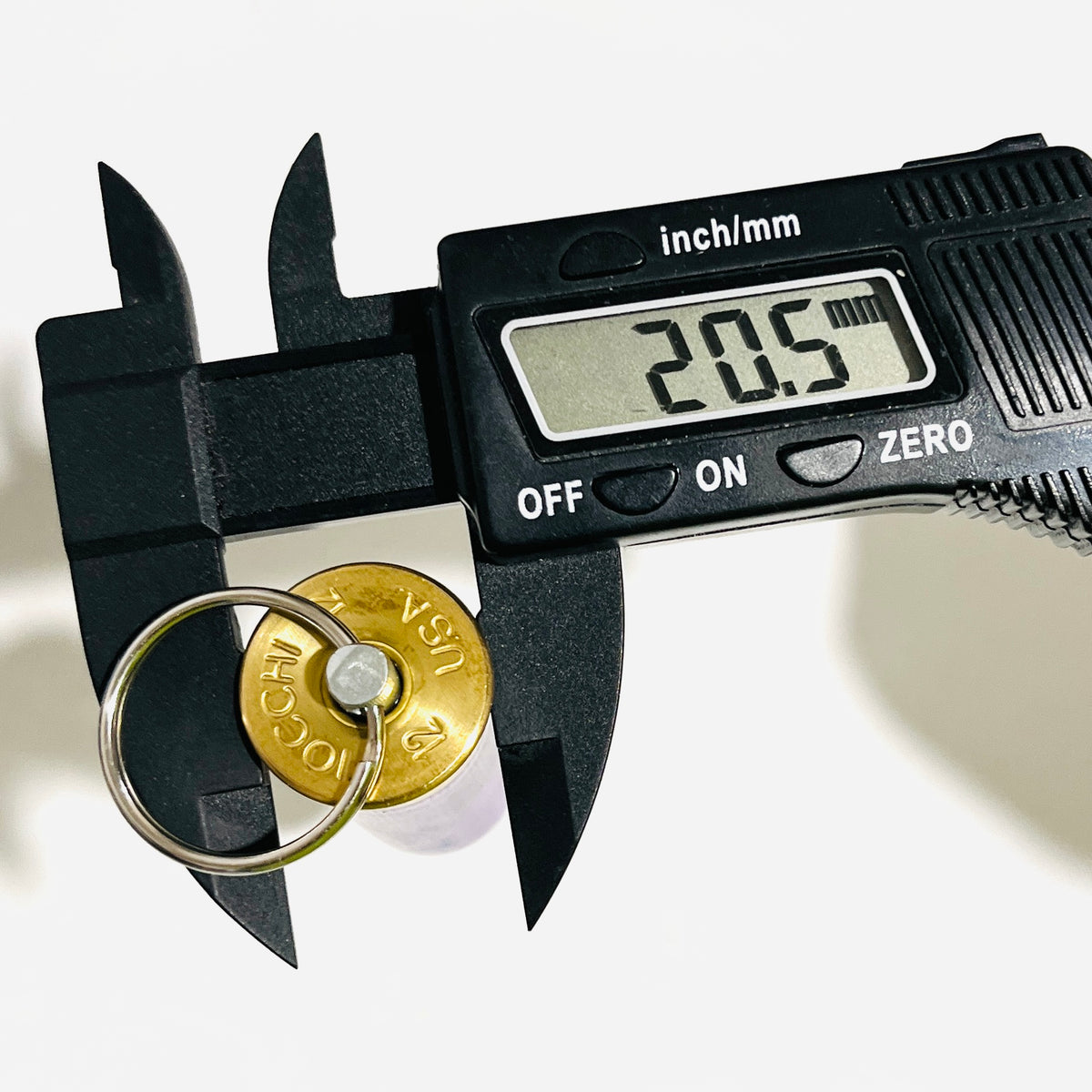 Digital caliper measuring the Fiocchi 12 gauge keychain head at 20.5 mm wide
