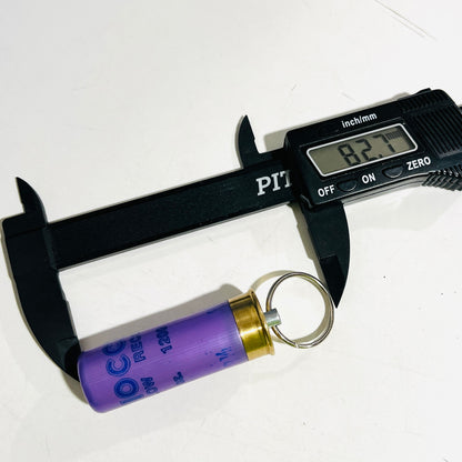 Digital caliper measuring the lavender Fiocchi shotgun shell keychain at 82.7 mm overall with hardware