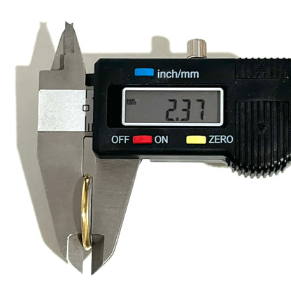 Digital caliper measuring the edge thickness of a gold Fiocchi shotgun shell slice at 2.37 mm
