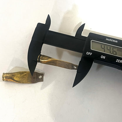 Digital caliper measuring the length of a flattened brass casing showing 44.6 mm with another casing beside it