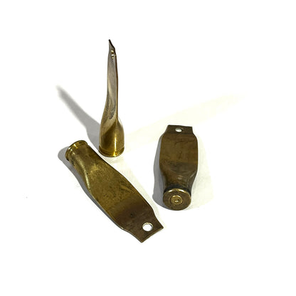 3 flattened brass casings in different shapes, one twisted, one paddle-shaped, one showing a headstamp base