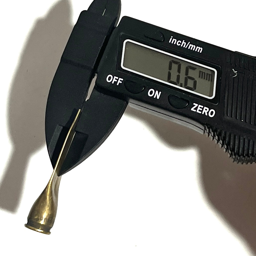 Digital caliper measuring the thickness of a twisted brass casing tip showing 0.6 mm