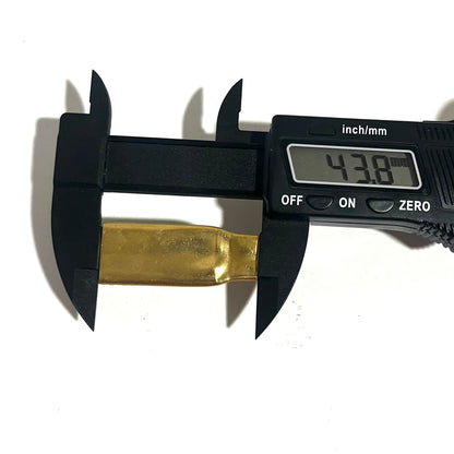 Digital caliper measuring the reverse side of a flattened .308 brass casing at 43.8 millimeters long