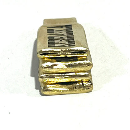 Stack of flattened brass .308 casings viewed from the edge showing rough-cut layered ends