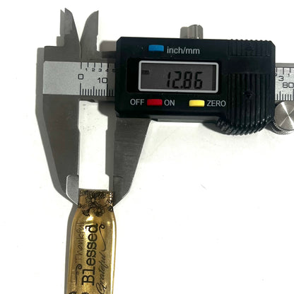 Digital caliper measuring the narrow end of an engraved flattened .308 brass casing at 12.86 millimeters wide