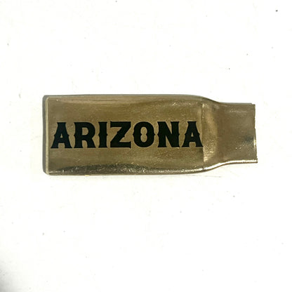 Flattened brass .308 casing engraved with Arizona in black lettering on a white background
