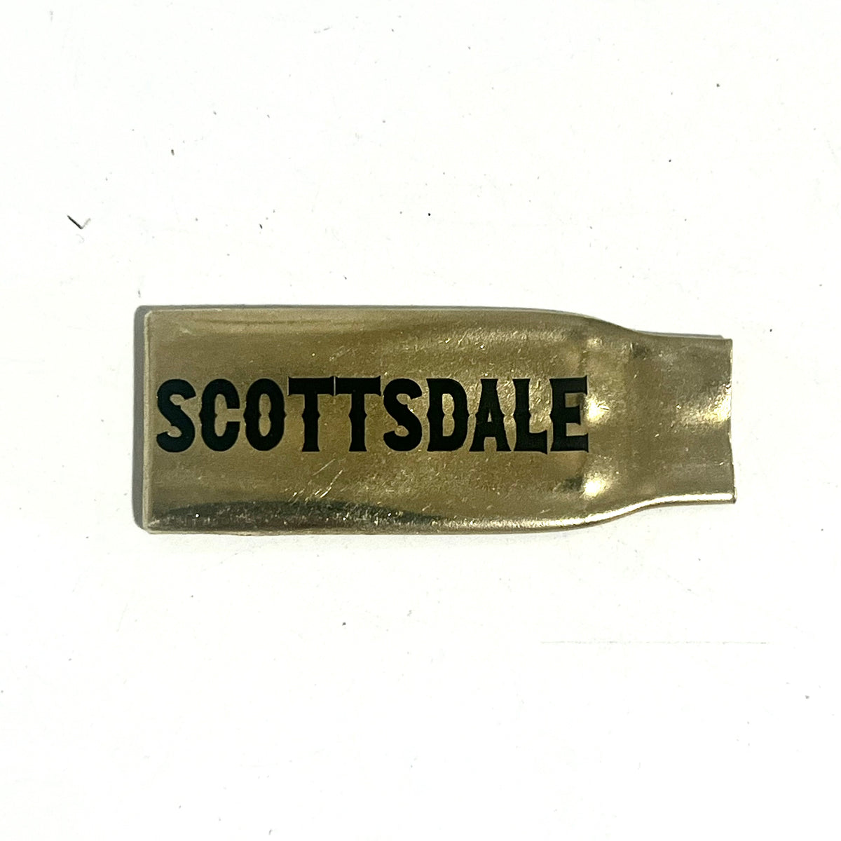 Flattened brass .308 casing engraved with Scottsdale in black lettering on a white background