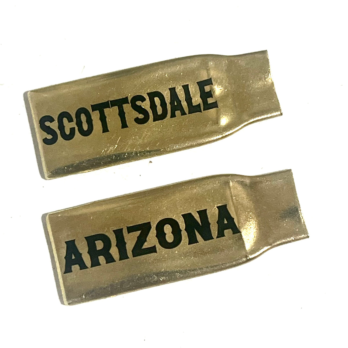 2 flattened brass .308 casings engraved with Scottsdale and Arizona in black lettering, lying on a white background