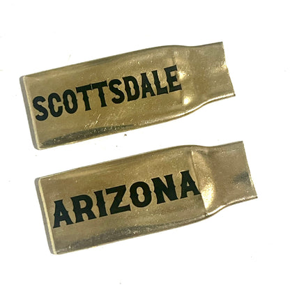2 flattened brass .308 casings engraved with Scottsdale and Arizona in black lettering, lying on a white background
