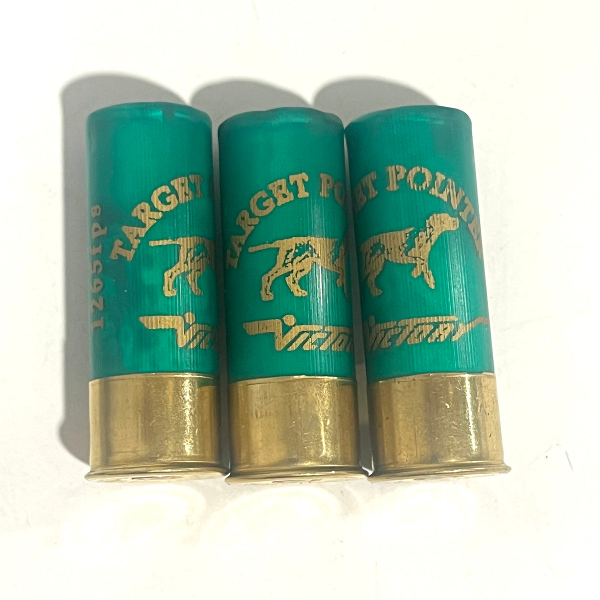 Three green spent shotgun cartridges standing with the full Target Pointer text and dog design visible