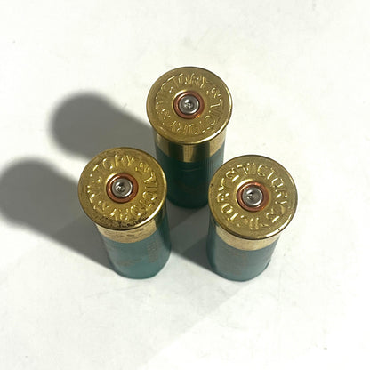 Three green empty dummy rounds shown base-up with Victory stamped on the brass headstamps