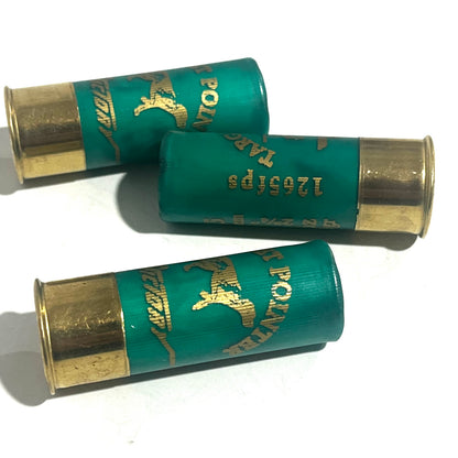 Three green spent shotgun hulls with gold bases and a 1205 fps marking, lying crossed on white
