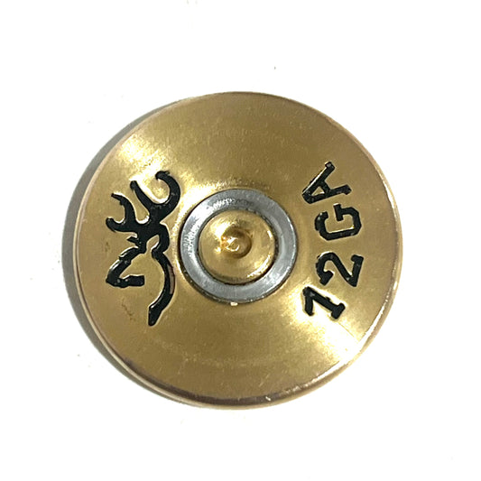 Gold 12 gauge shotgun shell slice with a Browning logo and 12GA stamped on it, close-up view