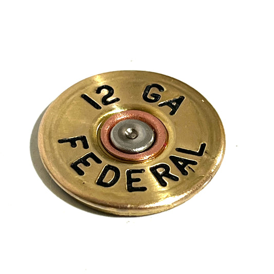 Round gold brass 12 gauge shotgun shell slice with black stamped lettering reading 12 GA FEDERAL