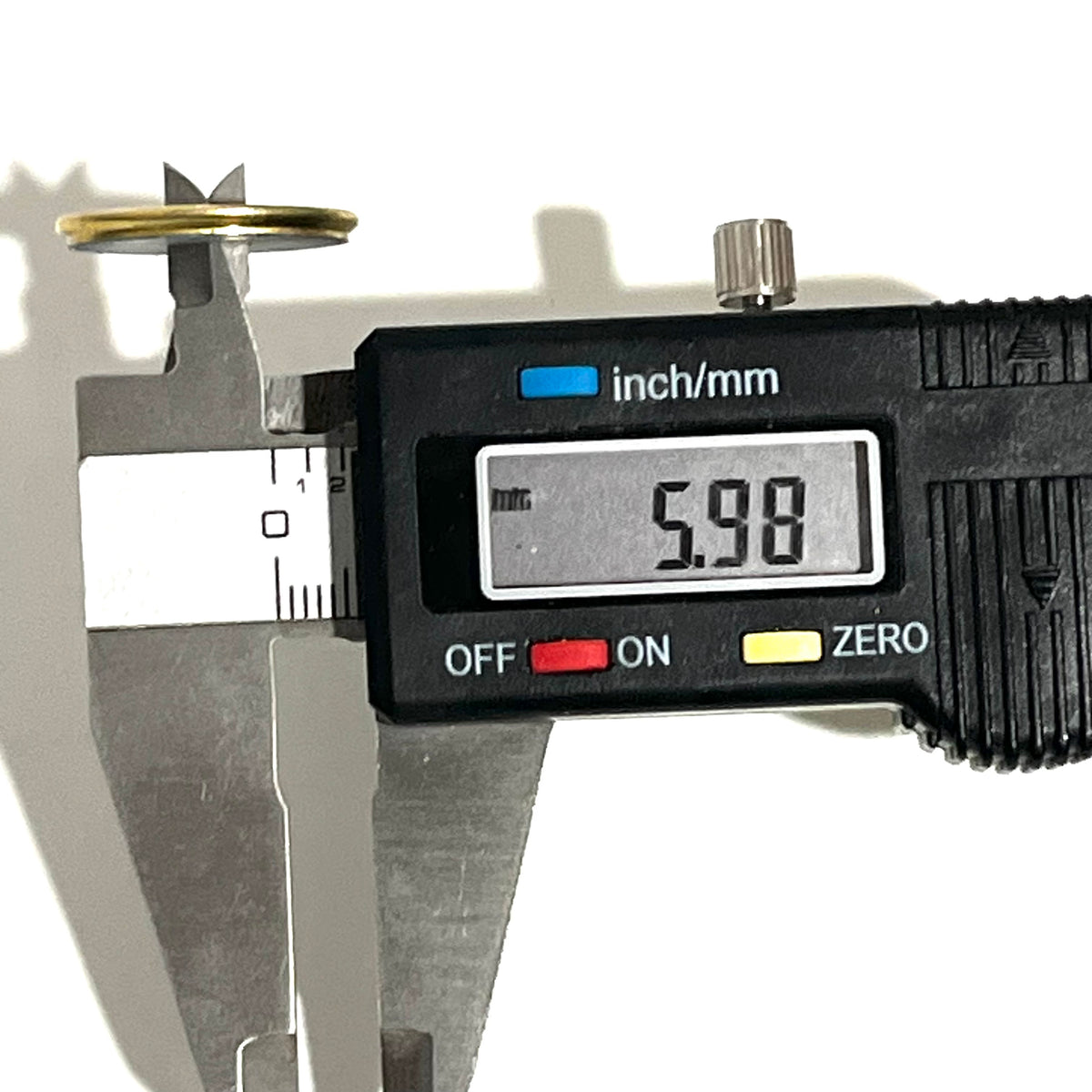 Digital caliper measuring the wall thickness of a deprimed 12 gauge brass shotgun shell slice at 5.98 mm