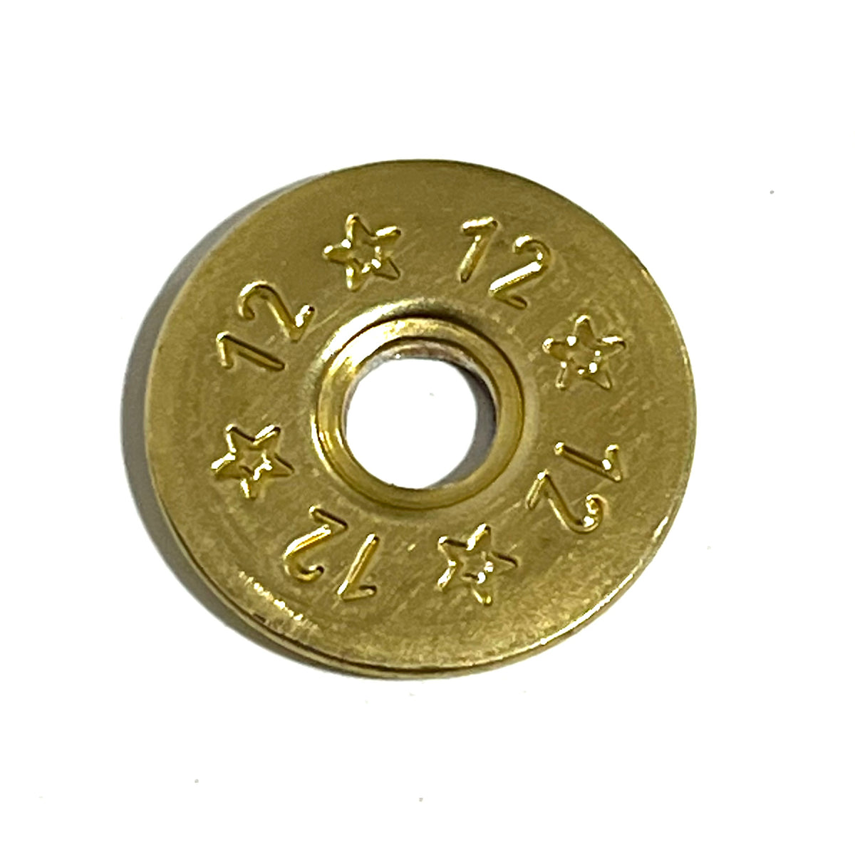 Single deprimed 12 gauge brass shotgun shell slice with 12 and star stamped design and open center hole on white background
