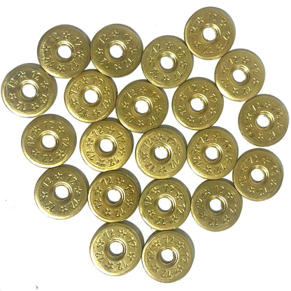 A grid of 20 deprimed 12 gauge brass shotgun shell slices with 12 and star stamped designs and open center holes on white background