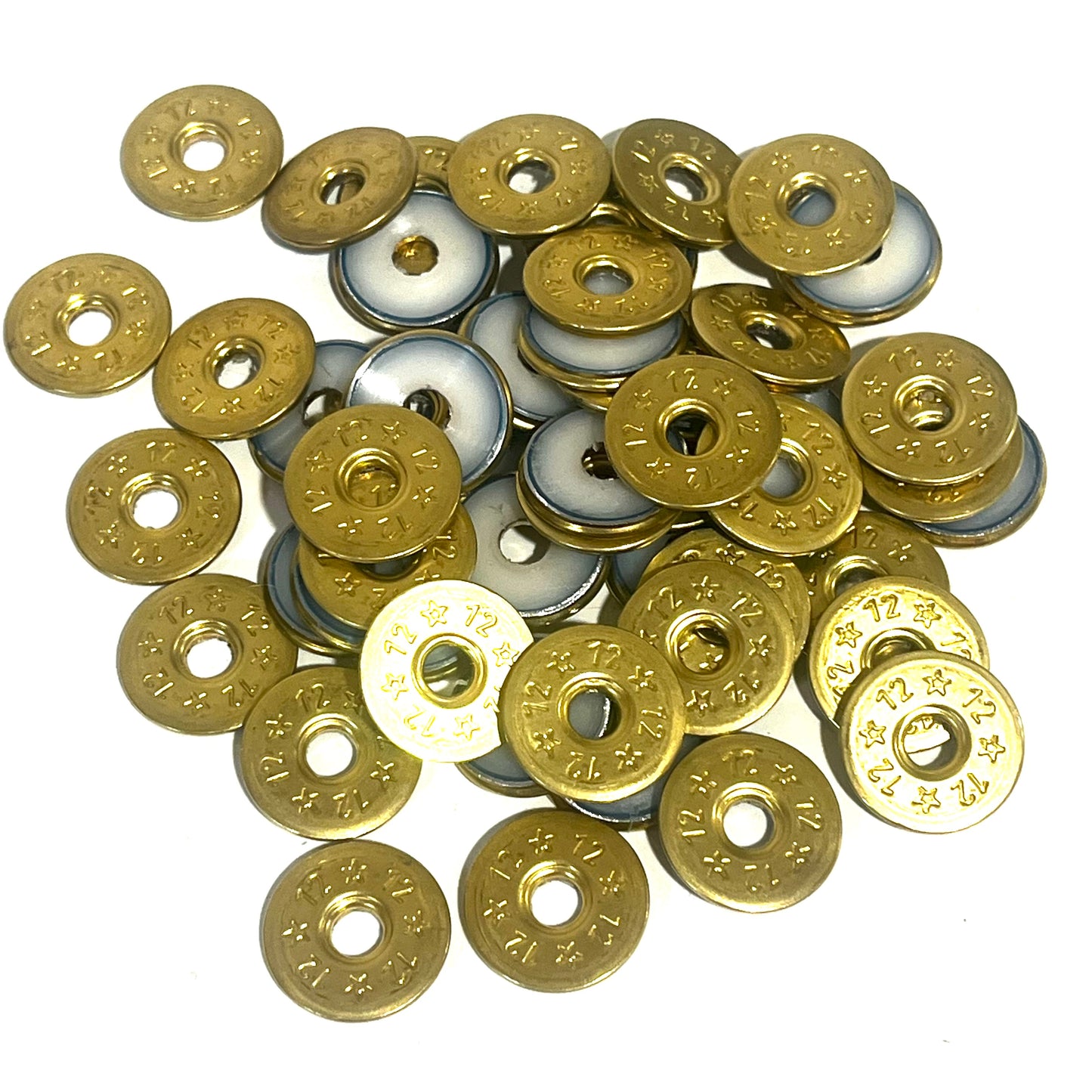 A pile of deprimed 12 gauge shotgun shell slices, some showing brass stamped 12 and star designs and others showing white plastic wad centers