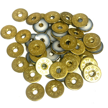 A pile of deprimed 12 gauge shotgun shell slices, some showing brass stamped 12 and star designs and others showing white plastic wad centers