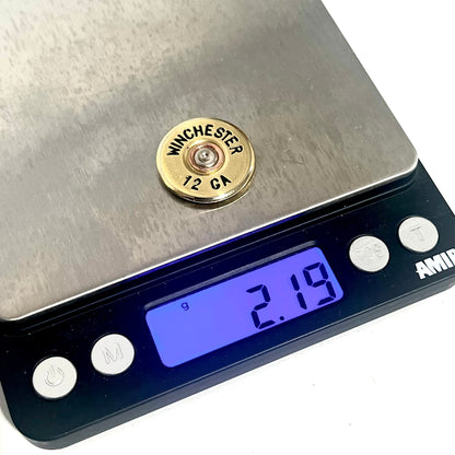Gold Winchester 12 GA shotgun shell slice on a digital scale reading 2.19 grams