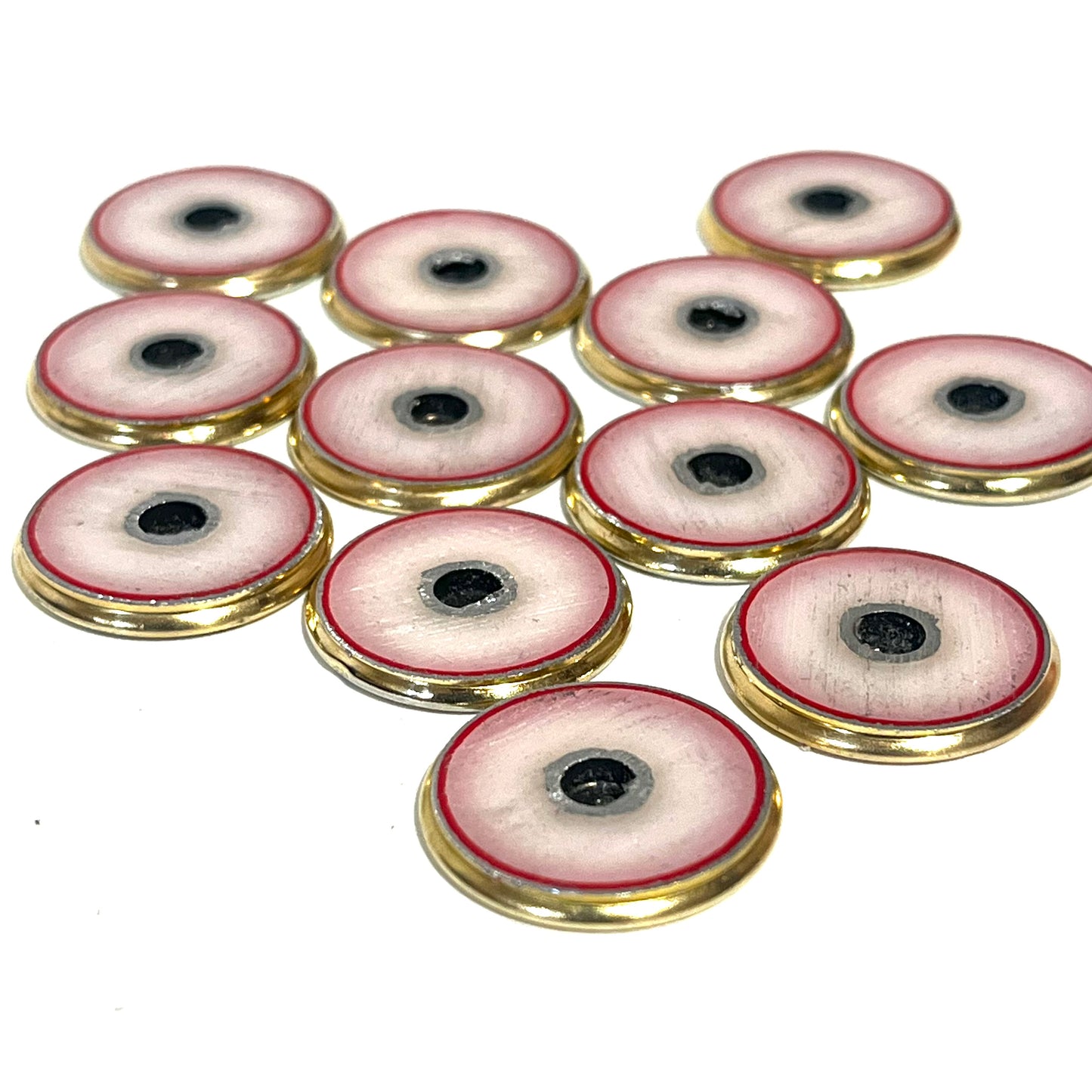 12 hand-painted shotgun shell slices with cream and red rims and black centers arranged in a cluster