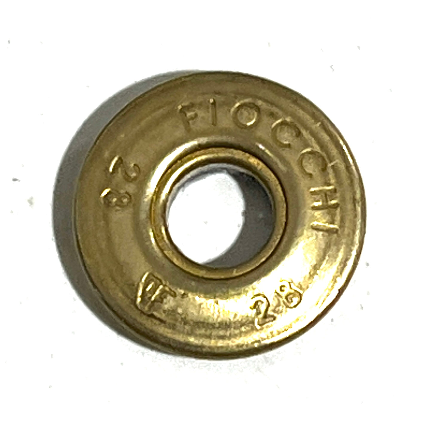 Close-up of a gold brass Fiocchi 28 gauge shotgun shell slice with a deprimed center