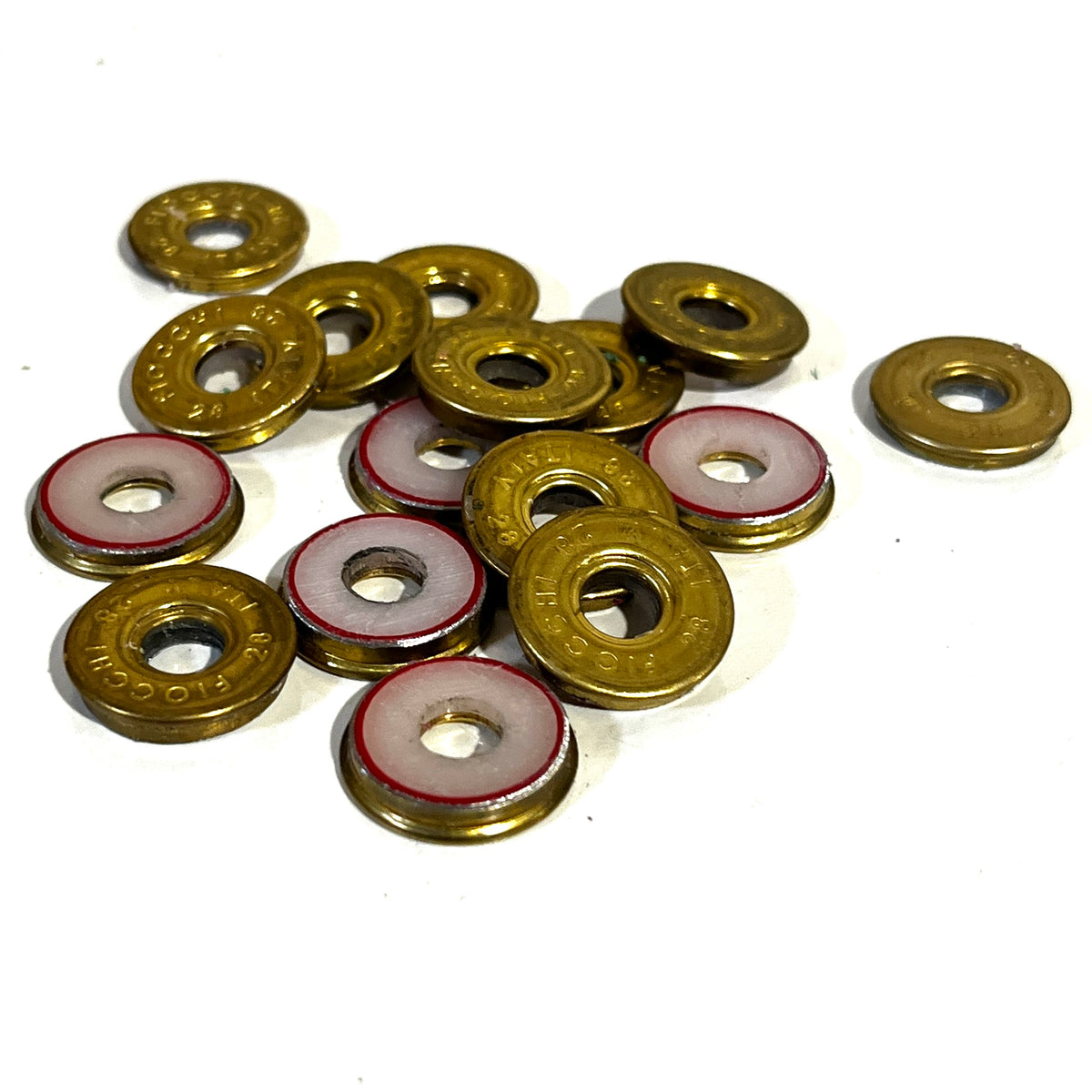 Group of gold brass Fiocchi 28 gauge shotgun shell slices, some with white and red painted centers