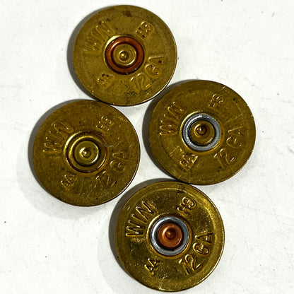 4 gold Winchester 12 gauge shotgun shell slices arranged in a diamond pattern showing headstamps