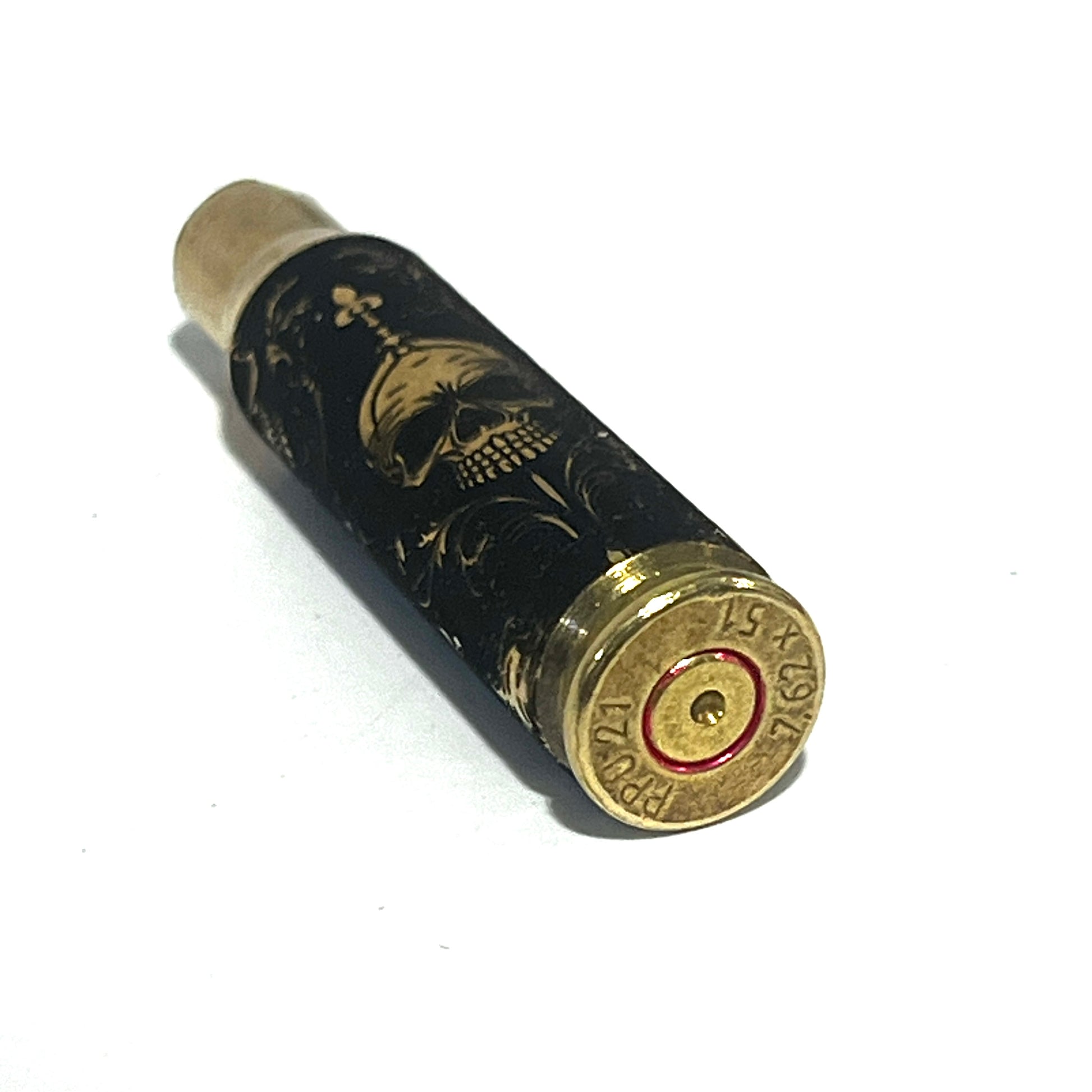 Brass rifle casing engraved with a gold gothic skull design, standing upright showing headstamp marked PPU 7.5x55