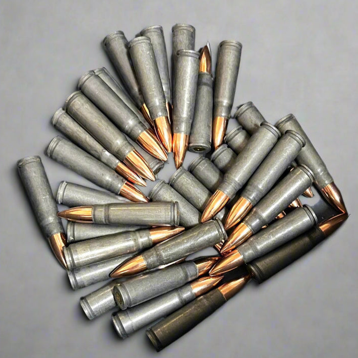 A large circular arrangement of gray dummy steel AK47 cartridges with copper bullets pointing toward the center.
