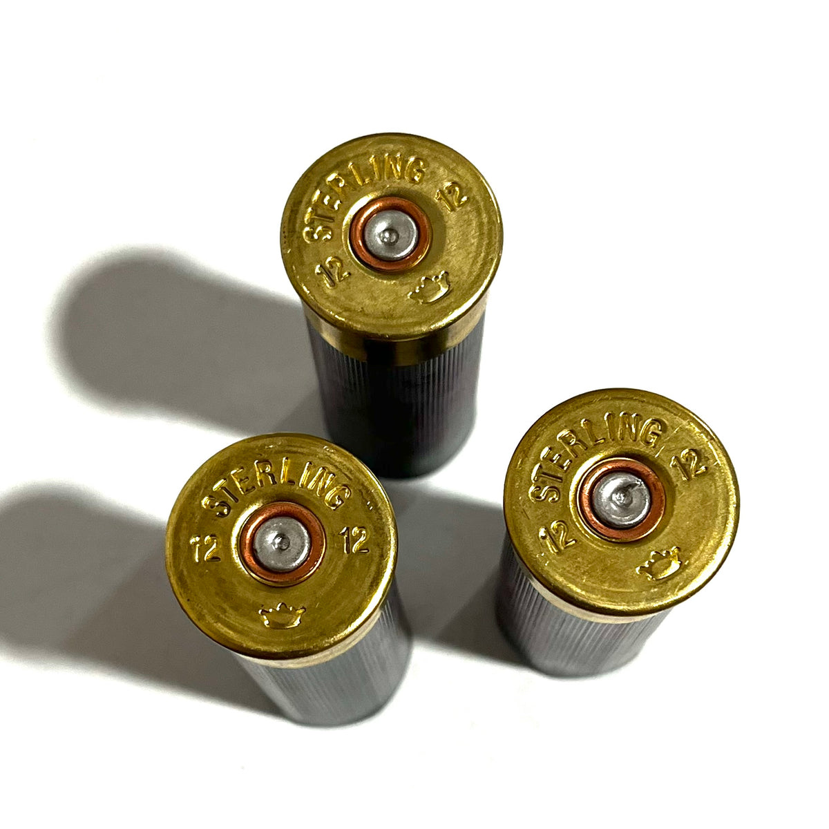 3 gray shotgun shells viewed from above showing brass Sterling 12 headstamps with copper primers