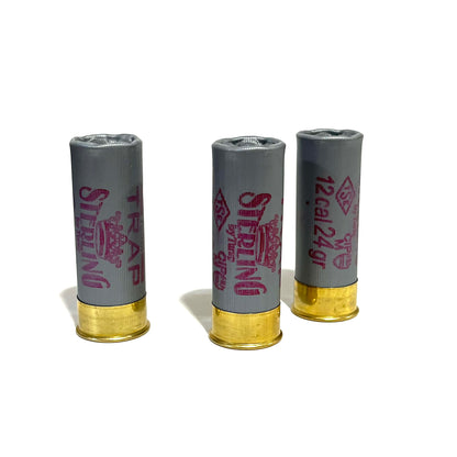 3 gray Sterling Trap 12 gauge shotgun shells standing upright with brass bases and pink text on a white background