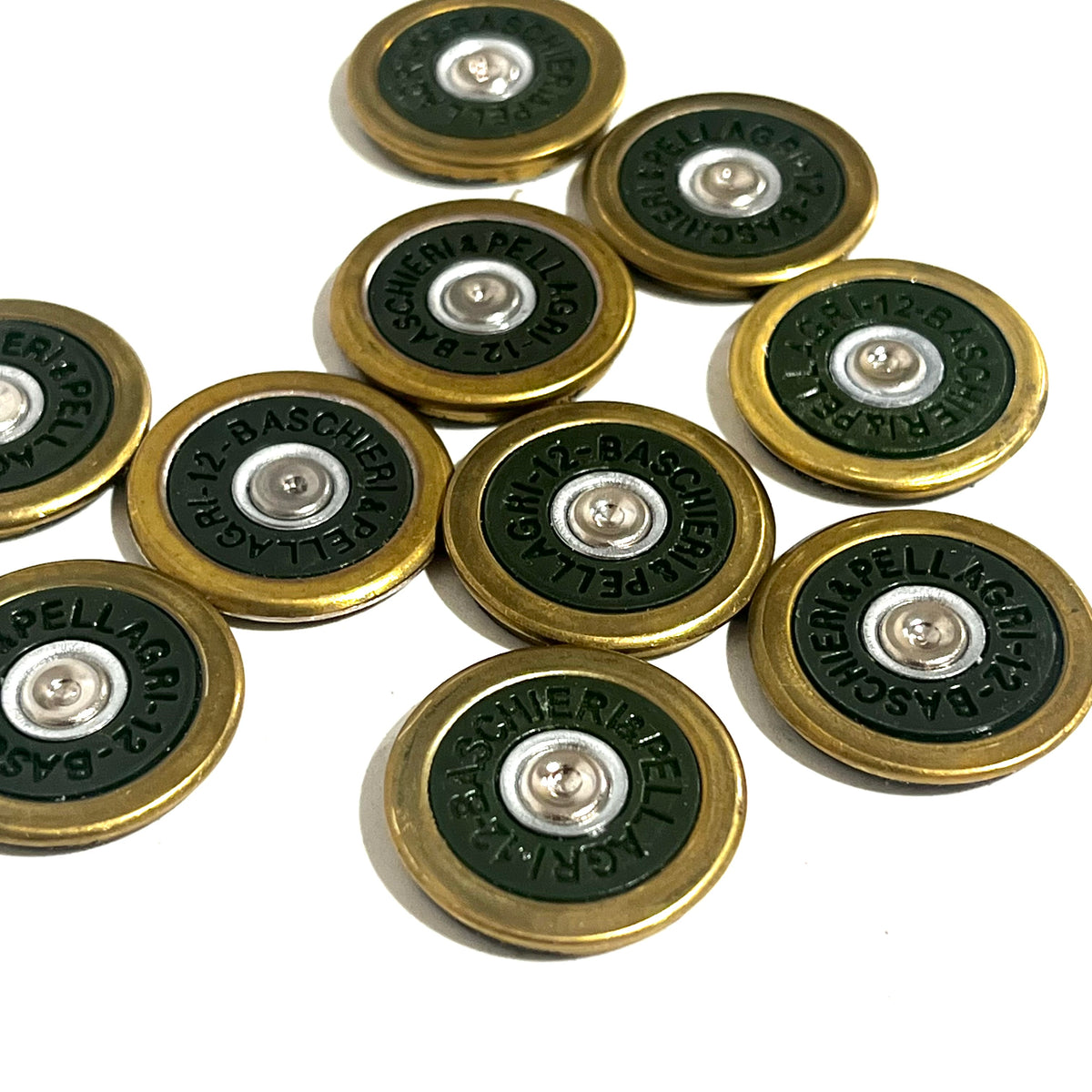 9 round brass shotgun shell slices with green undersides arranged in a cluster showing Baschieri Pellagri headstamps