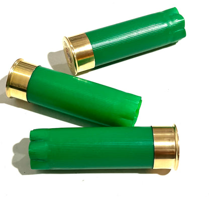 3 empty green 12 gauge shotgun shells with crimped ends and brass bases arranged on a white background
